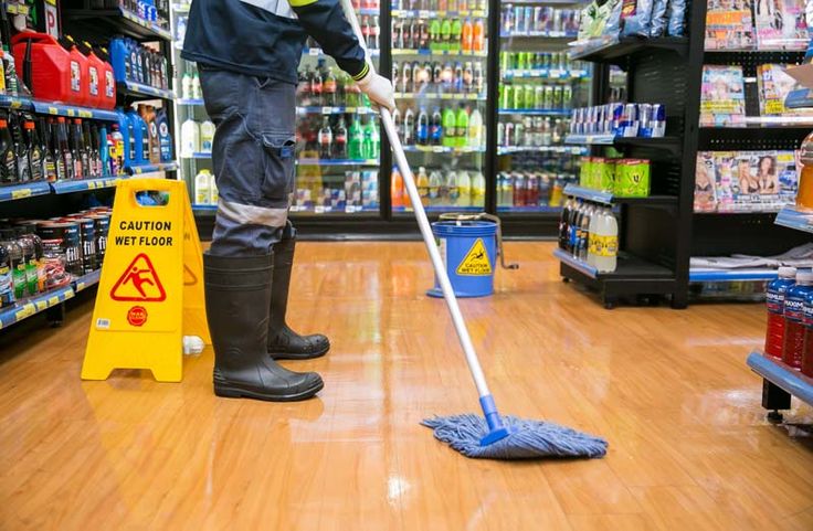 Store aisle floor mopped with a wet-floor caution sign in place